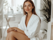 Woman after painless laser hair removal sitting in a clean white beauty clinic, smiling and relaxed
